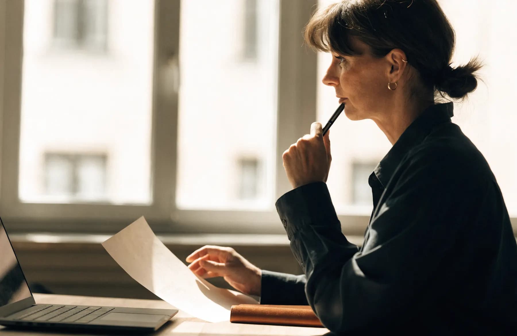 A reviewer comparing a printed document against a laptop screen