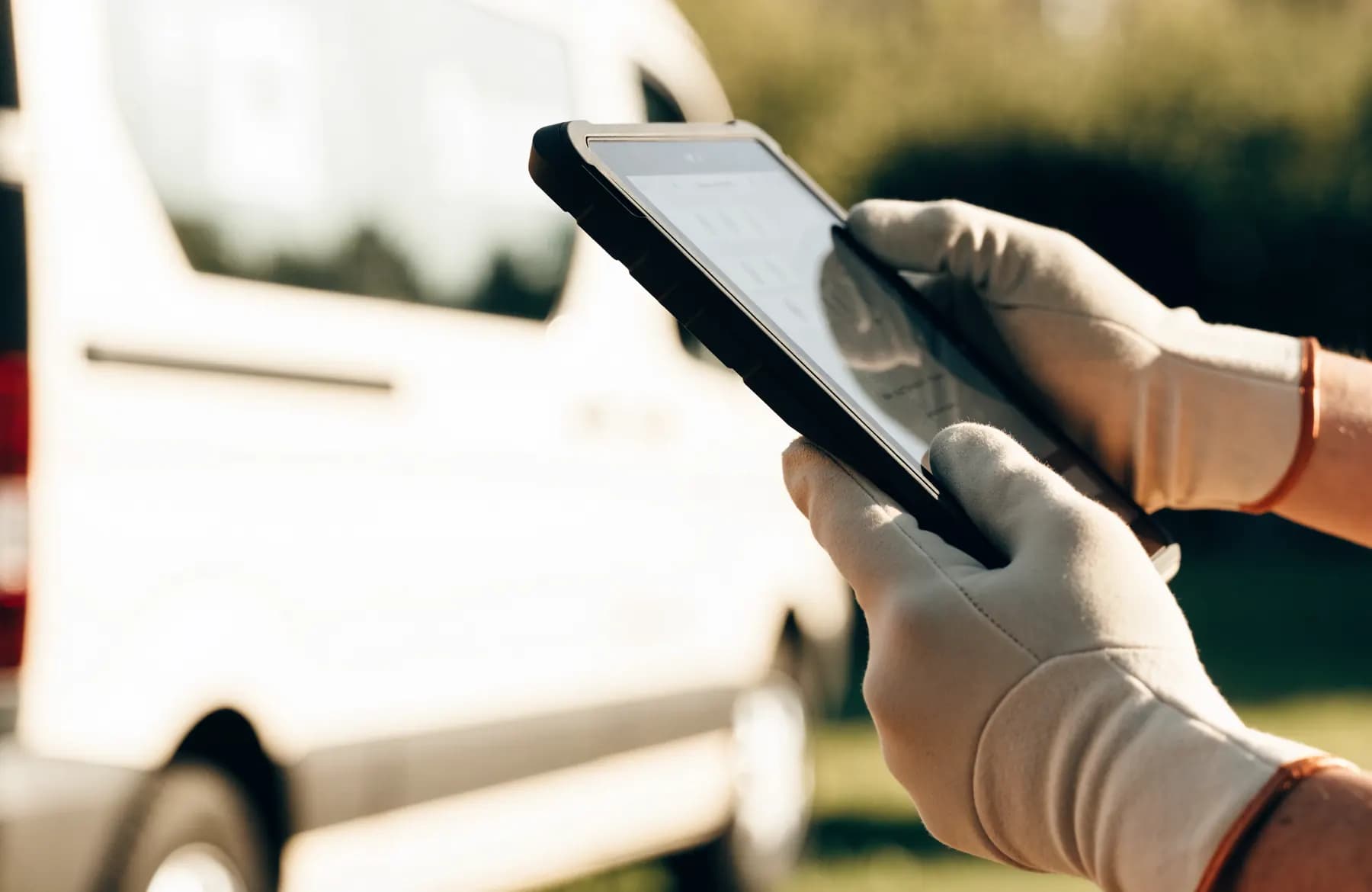 A field technician holding a rugged tablet showing a job checklist
