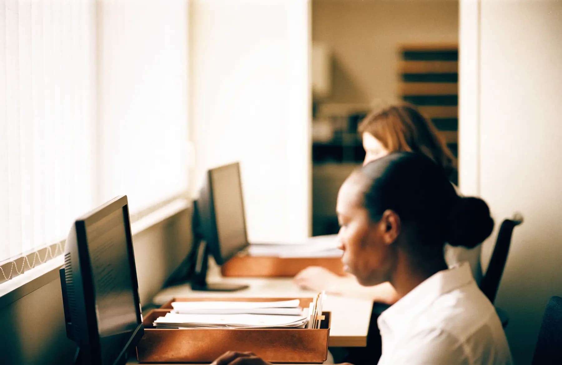 Administrators working at computers in a healthcare back office