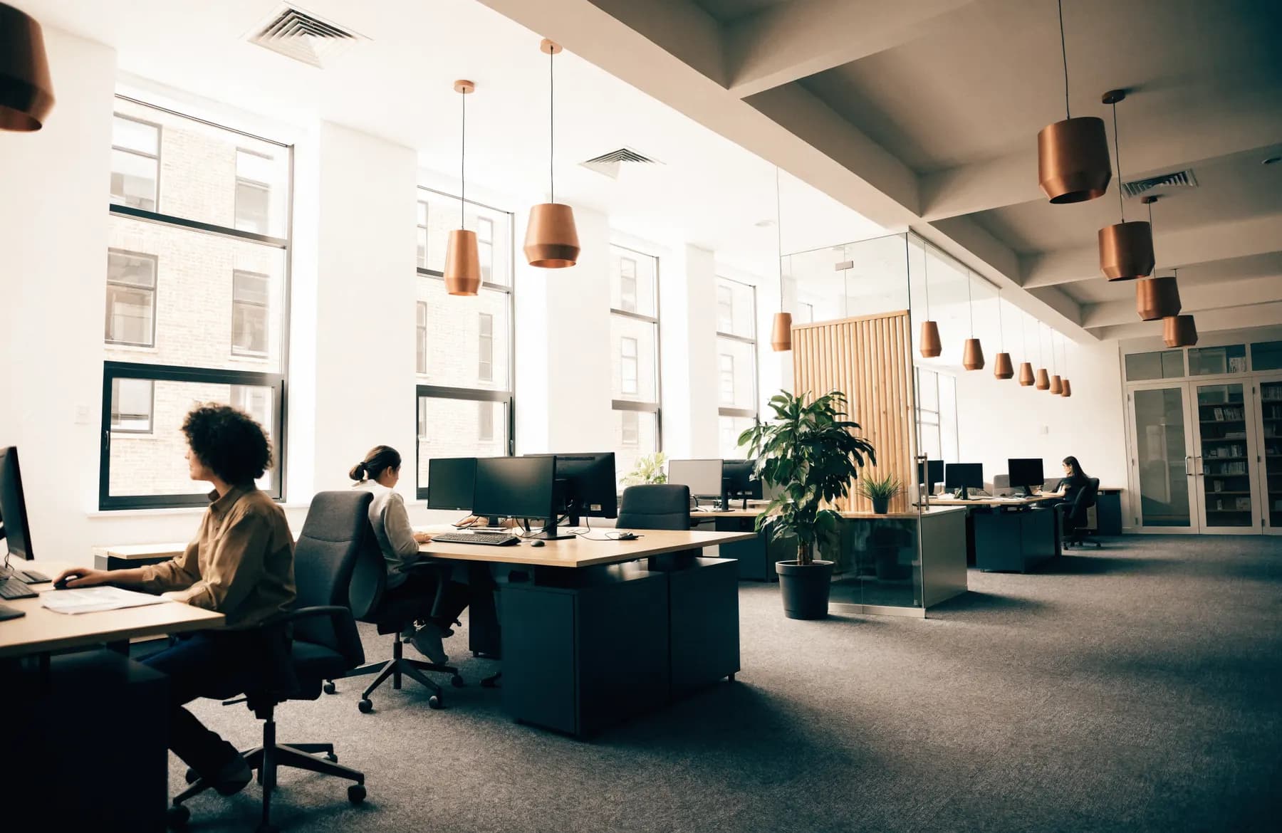 A calm professional services office with people working at spaced desks